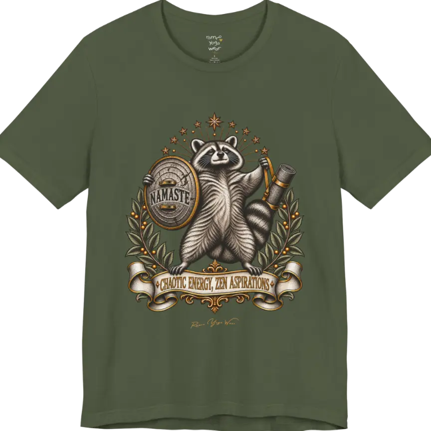 Illustrated raccoon crest holding a shield stamped "Namaste" and a rolled yoga mat, framed by stars and botanical laurel branches. Chaotic Zen T-Shirt flat lay is a Bella+Canvas 3001 and the color in Military Green.