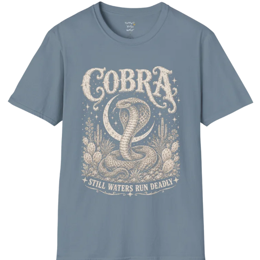 A grunge tee with an illustrated cobra design, hood flared, botanical linework framing the scene, text reading "Cobra" and "Still Waters Run Deadly" — Wild Animals collection by Ramro Yoga Wear in Stone Blue.