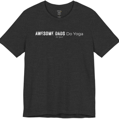 A short sleeved tee called the Dads T-Shirt, flat lay and a soft cotton blend shirt. Simply says, Awesome Dads Do Yoga. Design highlights bold distressed block lettering for Awesome Dads beside lighter thin lettering for Do Yoga, with a small script signature underneath. Color is Dark Heather Grey.