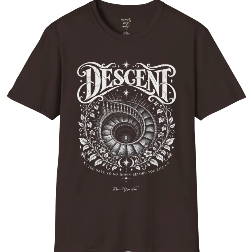 Spiral staircase descending into darkness with a single small light glowing at the bottom, fine botanical framing around the stairwell. Descent T-Shirt flat lay is a short sleeved tee, Gildan 64000 and the color is Dark Chocolate.