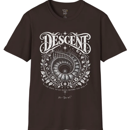 Spiral staircase descending into darkness with a single small light glowing at the bottom, fine botanical framing around the stairwell. Descent T-Shirt flat lay is a short sleeved tee, Gildan 64000 and the color is Dark Chocolate.