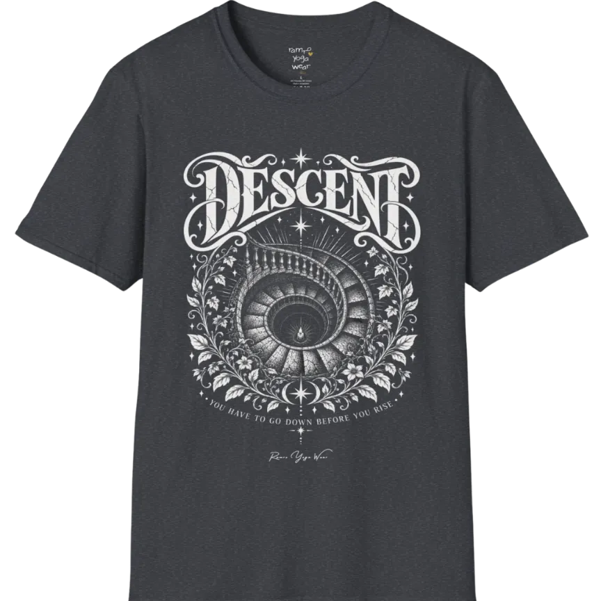 Spiral staircase descending into darkness with a single small light glowing at the bottom, fine botanical framing around the stairwell. Descent T-Shirt flat lay is a short sleeved tee, Gildan 64000 and the color is Dark Heather Grey.