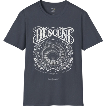 Spiral staircase descending into darkness with a single small light glowing at the bottom, fine botanical framing around the stairwell. Descent T-Shirt flat lay is a short sleeved tee, Gildan 64000 and the color is Heather Navy.