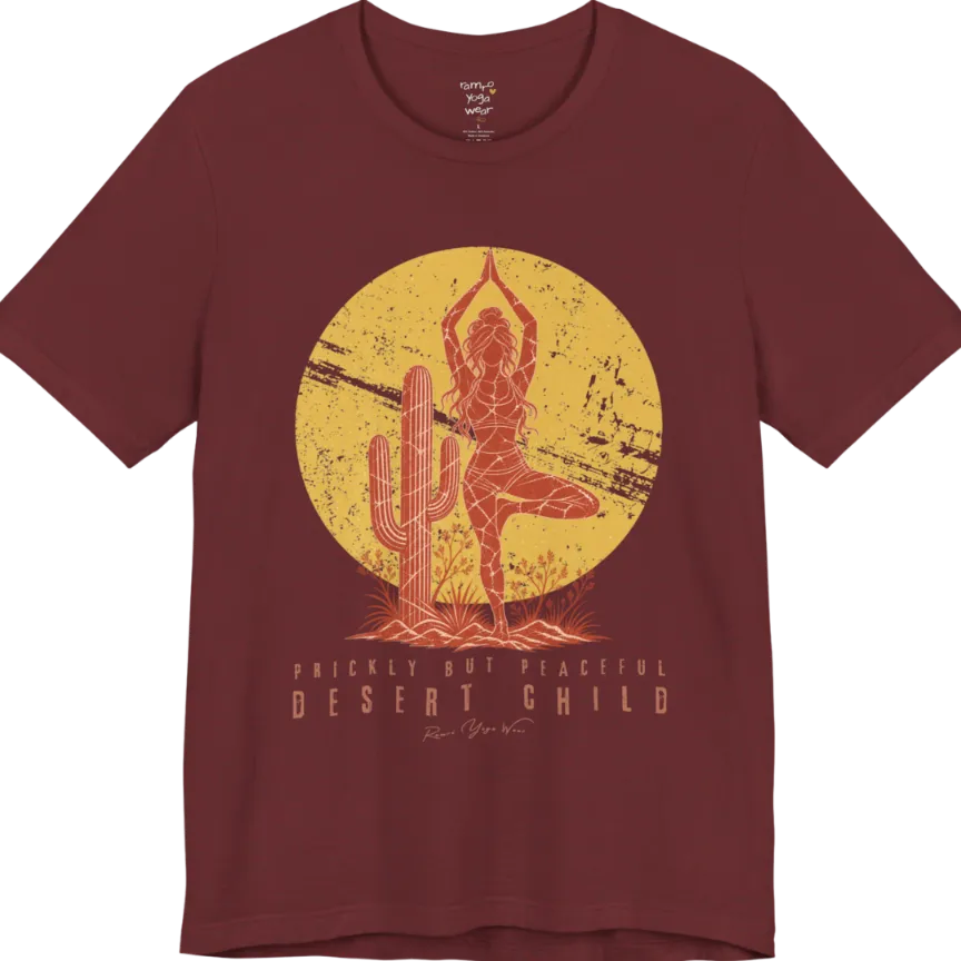 A short sleeved tee called the Desert Child T-Shirt, flat lay and a Bella + Canvas 3001 shirt. Simply says, Prickly But Peaceful, Desert Child. Design highlights a person in Tree Pose beside a desert cactus, with a large distressed sun in the background, in a rustic, distressed illustration. Color is Heather Cardinal.