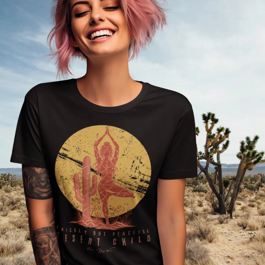 Person wearing the Desert Child T-Shirt, Prickly But Peaceful design, standing in the desert among Joshua trees, in Black