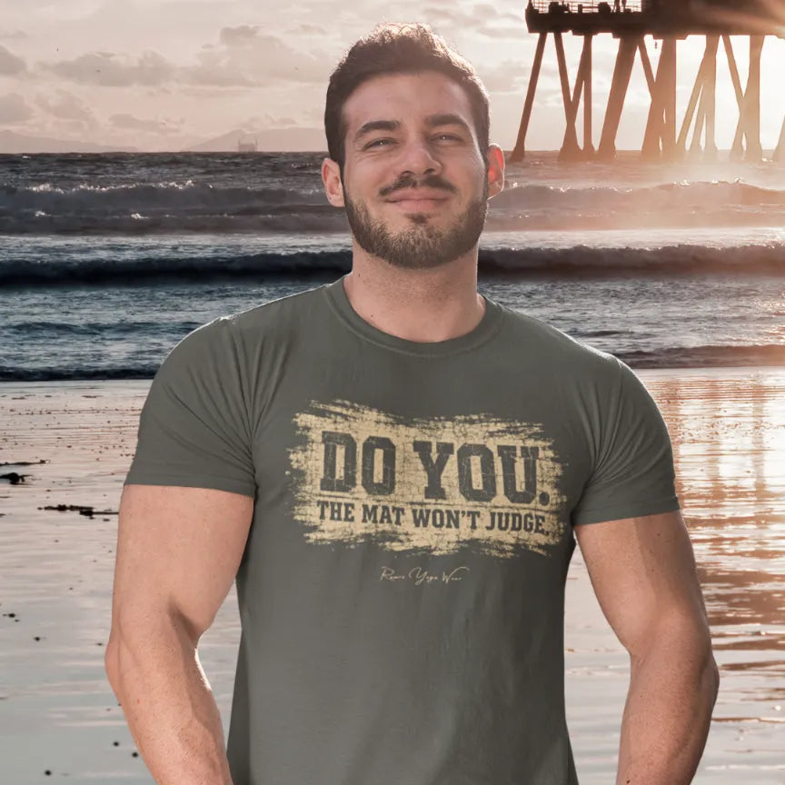 Person wearing Do You tee in Heather Military Green, a sacred yoga shirt at the beach with a pier in the background — Funny Yoga Shirts collection by Ramro Yoga Wear