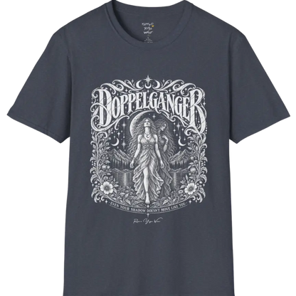 A short sleeved tee called the Doppelganger T-Shirt, flat lay and a Gildan 64000 shirt. Simply says, Even Your Shadow Doesn't Move Like You. Design highlights a woman standing before a crescent moon with a second shadow-self figure behind her, framed by mountains, florals, and ornate engraved linework border. Color is Heather Navy.