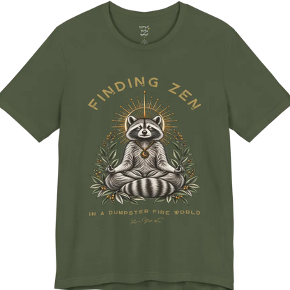 A short sleeved Tee of a meditating raccoon illustration with a gold sunburst halo and botanical leaf framing. Dumpster T-Shirt flat lay is a Bella+Canvas 3001 and the color is Military Green.