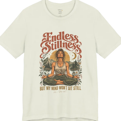 A short sleeved tee, showing an Illustration of a woman seated in lotus meditation pose in front of mountains, pine trees, and a crescent moon, framed by botanical leaves and flowers. Endless T-Shirt flat lay is a Bella+Canvas 3001 and the color is Citron.