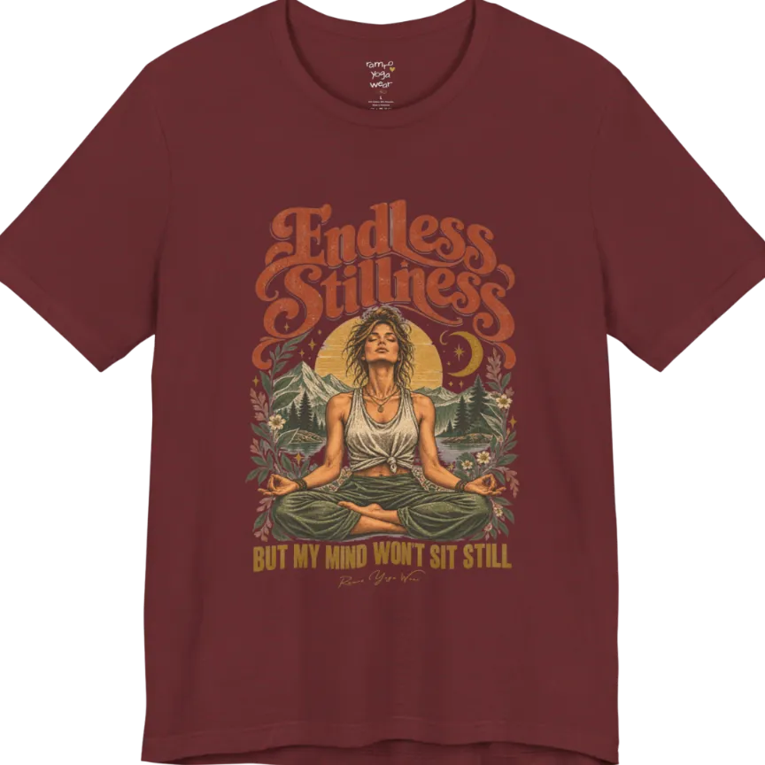 A short sleeved tee, showing an Illustration of a woman seated in lotus meditation pose in front of mountains, pine trees, and a crescent moon, framed by botanical leaves and flowers. Endless T-Shirt flat lay is a Bella+Canvas 3001 and the color is Heather Cardinal.