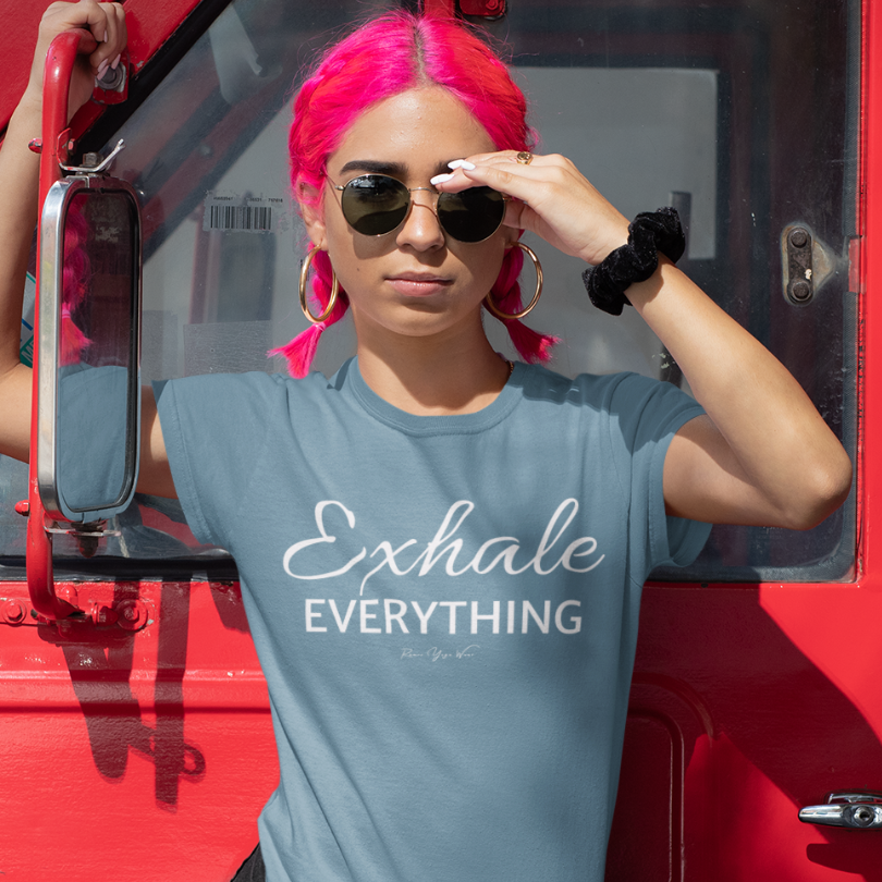 Woman wearing Exhale Everything Stone Blue T-Shirt outdoors at night, pink hair, sunglasses, hand raised — The Vault collection by Ramro Yoga Wear