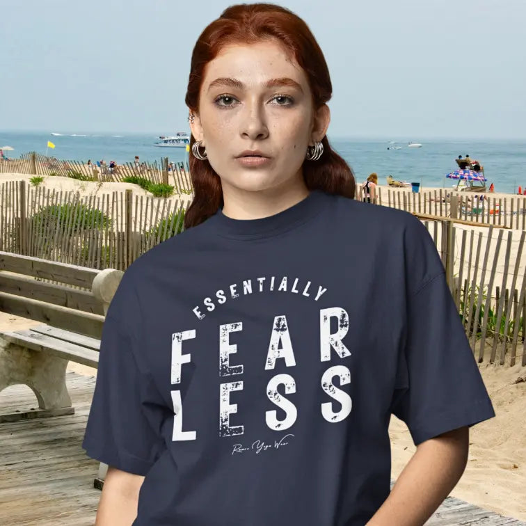 Person wearing the Fear Less T-Shirt in Heather Midnight Navy, outdoors near a beach boardwalk — Funny Yoga Shirts collection by Ramro Yoga Wear.