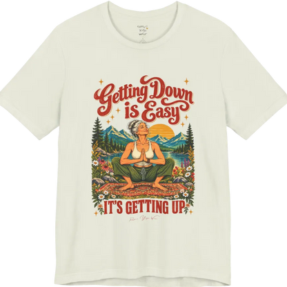 A short sleeved tee called the Getting Up T-Shirt, flat lay and a soft cotton blend shirt. Simply says, Getting Down is Easy, It's Getting Up. Design highlights retro red script lettering above a silver-haired person in a deep yoga squat with hands in prayer on a patterned mat, with a sun, mountains, a lake and wildflowers, bold red lettering for IT'S GETTING UP and a small script signature. Color is Citron.