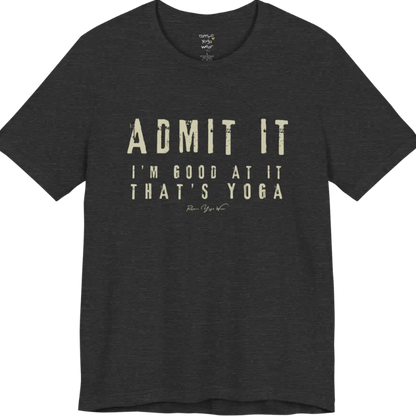 A short sleeved tee called the Good T-Shirt, flat lay and a Bella+Canvas 3001 shirt. Simply says, Admit It, I'm Good At It, That's Yoga. Design highlights bold distressed cream lettering with ADMIT IT large above two smaller lines of wide-spaced text. Color is Dark Grey Heather.
