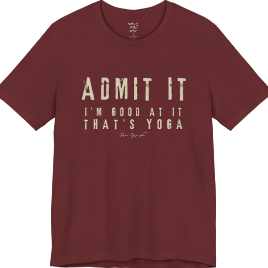 A short sleeved tee called the Good T-Shirt, flat lay and a Bella+Canvas 3001 shirt. Simply says, Admit It, I'm Good At It, That's Yoga. Design highlights bold distressed cream lettering with ADMIT IT large above two smaller lines of wide-spaced text. Color is Heather Cardinal.
