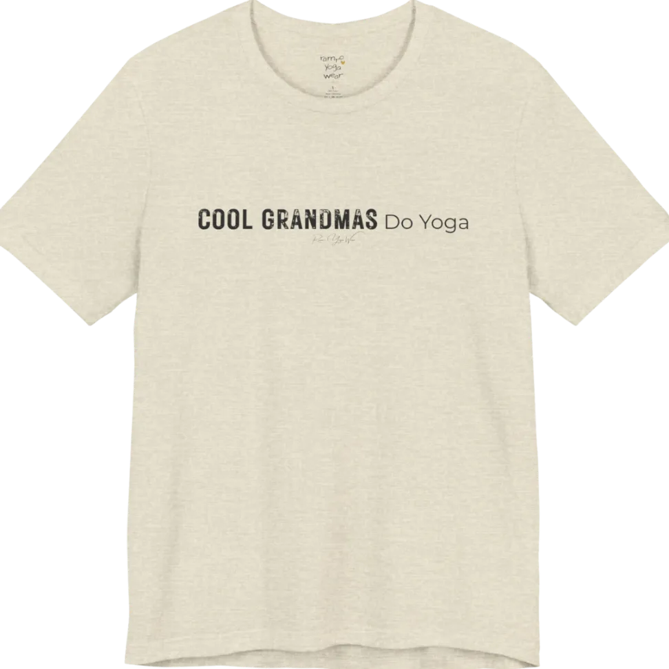 A short sleeved tee called the Grandmas T-Shirt, flat lay and a soft cotton blend shirt. Simply says, Cool Grandmas Do Yoga. Design highlights bold distressed block lettering for COOL GRANDMAS beside thin lettering for Do Yoga, with a small script signature underneath. Color is Heather Prism Natural.