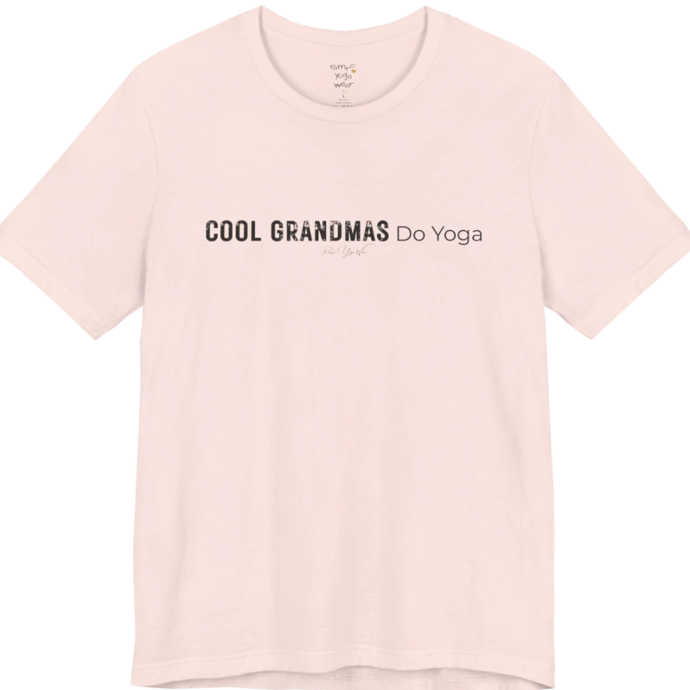 A short sleeved tee called the Grandmas T-Shirt, flat lay and a soft cotton blend shirt. Simply says, Cool Grandmas Do Yoga. Design highlights bold distressed block lettering for COOL GRANDMAS beside thin lettering for Do Yoga, with a small script signature underneath. Color is Soft Pink.