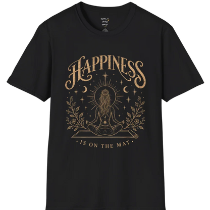 A short sleeved tee called the Happiness T-Shirt, flat lay and a soft cotton shirt. Simply says, Happiness is on the mat. Design highlights ornate warm gold HAPPINESS lettering above a figure meditating cross-legged on a yoga mat, seen from behind beneath a thin sun halo, with crescent moons, stars and botanical sprigs. Color is Black.