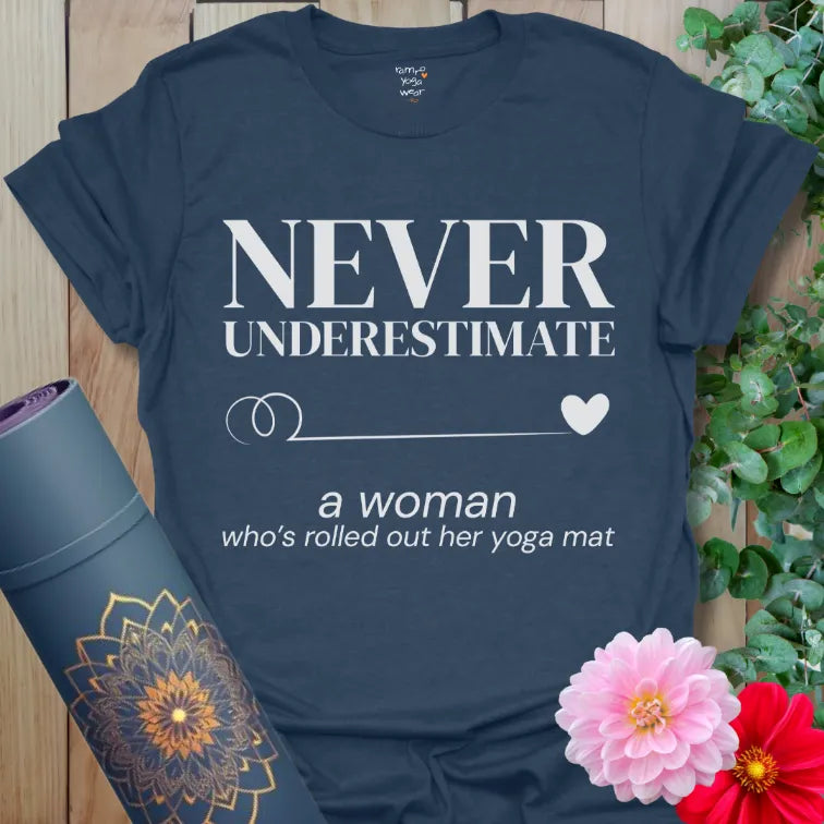 Heather Navy Never Underestimate T-Shirt with bold white typography. Strong yoga quote with feminine swirl detail and heart.