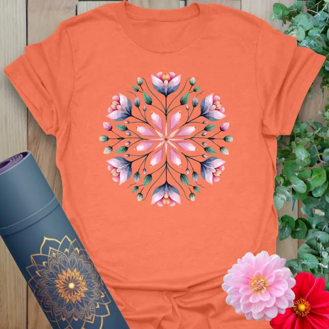Vibrant orange yoga t-shirt showcasing blooming mandala of flowers for soulful, nature-connected movement.