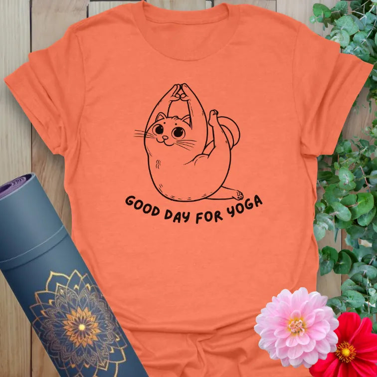 Vibrant orange yoga t-shirt showcasing playful yoga cat illustration and cheerful mantra inspiring joyful movement.