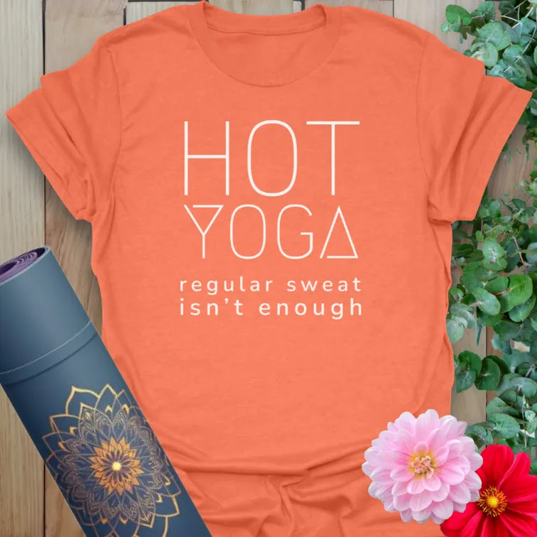 Vibrant orange yoga t-shirt showcasing minimalist hot yoga humor design inspiring conscious movement and strength.