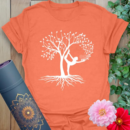 Vibrant orange yoga t-shirt showcasing graceful Tree Pose yogi and flourishing tree design for mindful, soulful living.