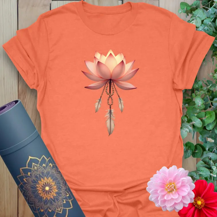Vibrant orange yoga t-shirt showcasing glowing lotus and feathers artwork symbolizing soulful resilience and beauty.