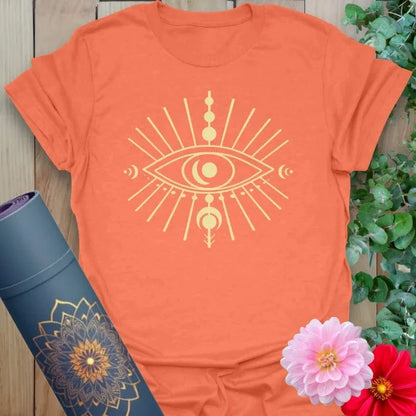 Vibrant orange yoga t-shirt showcasing mystical eye artwork with lunar phases symbolizing intuition and conscious growth.