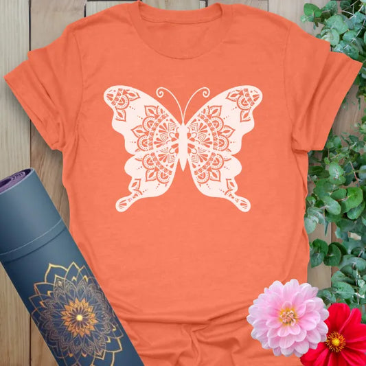 Vibrant orange yoga t-shirt showcasing sacred mandala butterfly artwork inspiring freedom, mindfulness, and spiritual beauty.