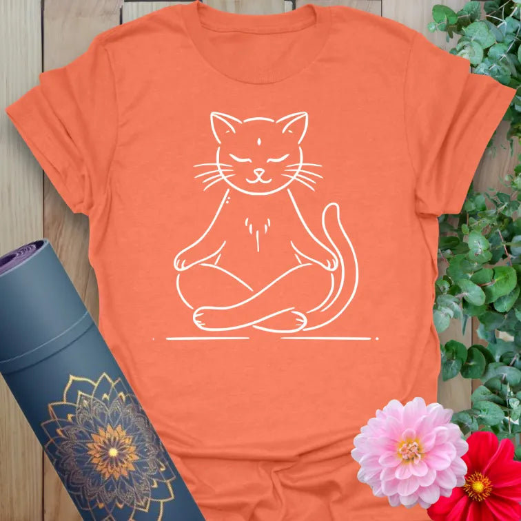Vibrant orange yoga t-shirt showcasing serene cat in meditation pose inspiring light-hearted mindfulness and joyful presence.
