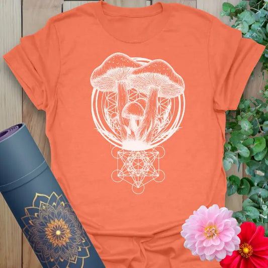 Vibrant orange yoga t-shirt showcasing sacred mushrooms and geometric root design inspiring soulful living and nature-centered growth.