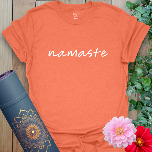 Vibrant orange yoga t-shirt showcasing elegant "namaste" handwriting design inspiring mindfulness and gratitude.