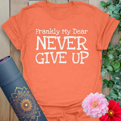 Vibrant orange yoga t-shirt showcasing bold motivational message inspiring conscious determination and courageous living.