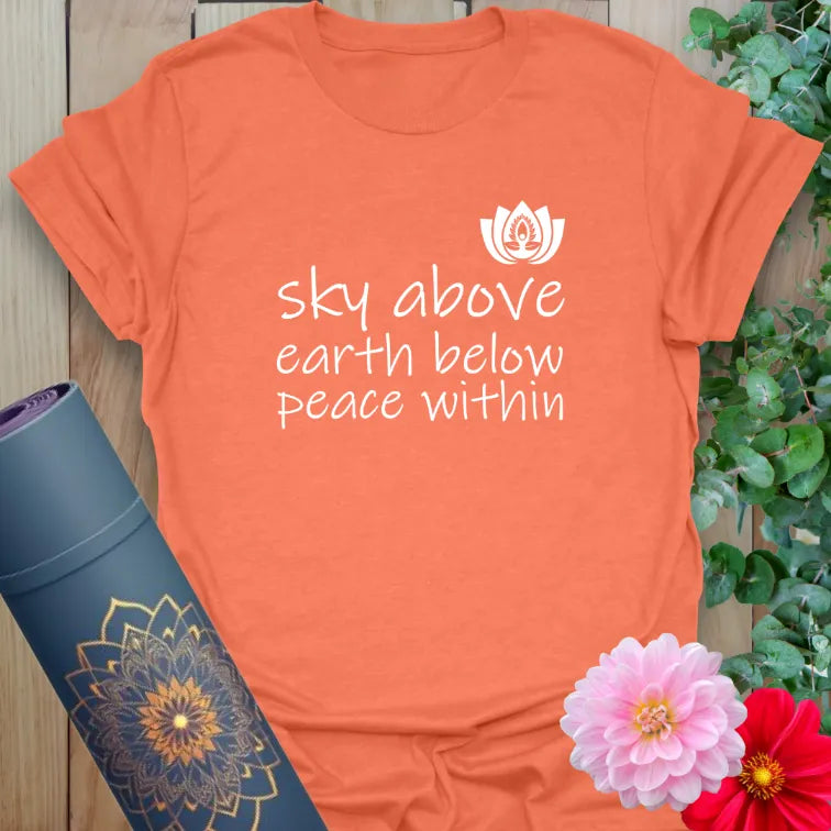 Vibrant orange yoga t-shirt showcasing peaceful mantra and lotus bloom inspiring conscious presence and heartfelt calm.