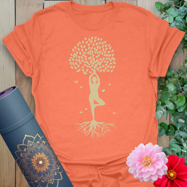 Vibrant orange t-shirt with graceful yoga figure in Tree Pose and leafy design symbolizing strength and spiritual grounding.