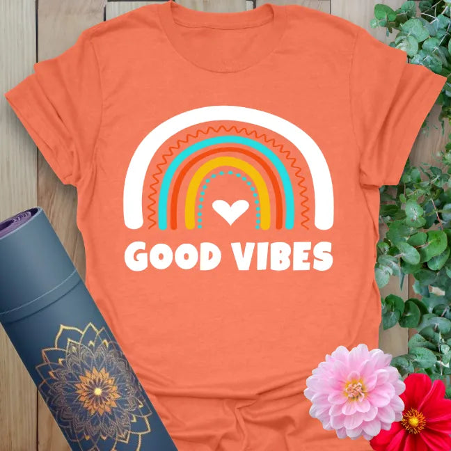 Vibrant orange t-shirt with heart-centered rainbow design and positive quote for radiant, uplifting yoga wear.