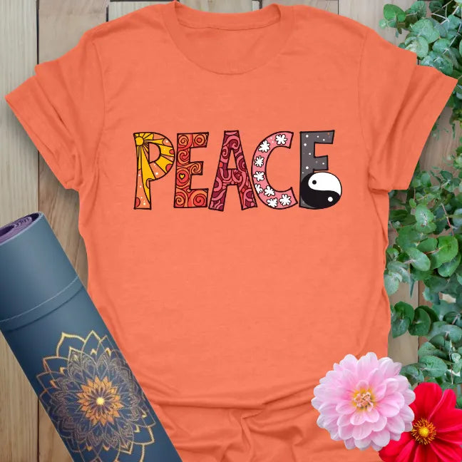 Vibrant orange t-shirt with stylized peace design and yin yang graphic for playful, spiritual style.
