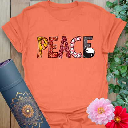 Vibrant orange t-shirt with stylized peace design and yin yang graphic for playful, spiritual style.