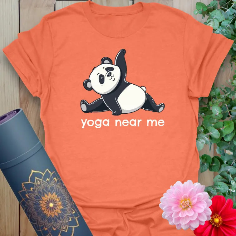 Vibrant orange yoga t-shirt featuring a stretching panda and funny yoga-inspired quote.