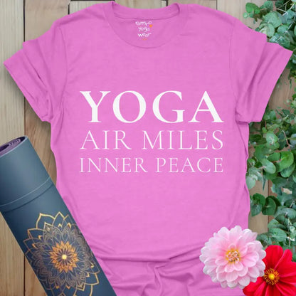 Heather Radiant Orchid Air Miles T-Shirt with white serif text reading “Yoga, Air Miles, Inner Peace.” Styled with yoga mat and floral accents.