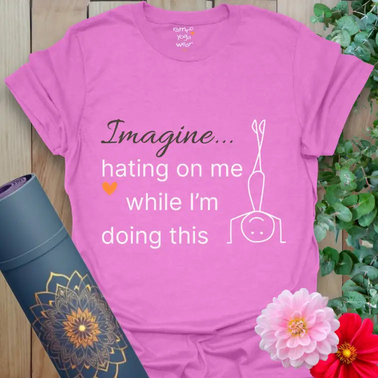 Heather Radiant Orchid Imagine T-Shirt with witty phrase “Imagine hating on me while I’m doing this.” Bold purple tone, white design, orange heart accent, and lighthearted yoga humor.