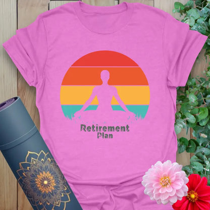 Radiant orchid-colored yoga tee with peaceful meditation figure and "Retirement Plan" design celebrating conscious, joyful living.