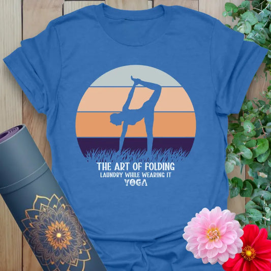 Soft cotton unisex yoga t-shirt featuring playful yogi silhouette and "Art of Folding Laundry" funny yoga quote against a retro sunset backdrop