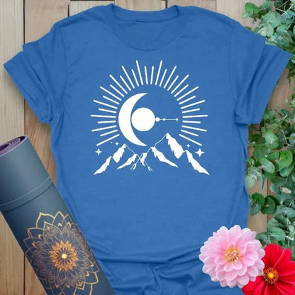 Soft cotton unisex yoga t-shirt featuring crescent moon rising over mountain peaks with radiant beams symbolizing cosmic beginnings and soulful adventure.