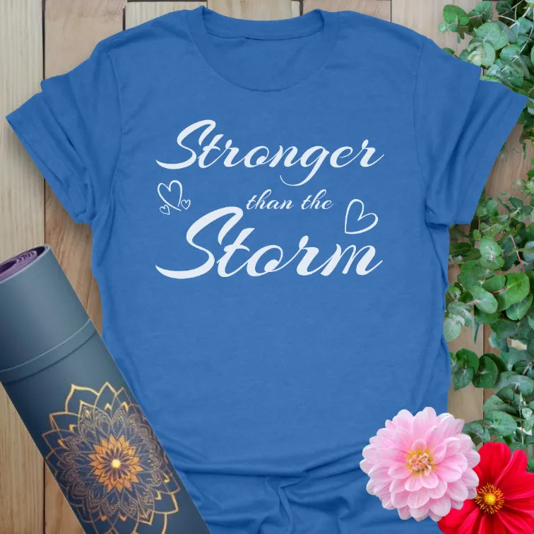 Soft cotton yoga t-shirt featuring “Stronger than the Storm” quote with heart and butterfly elements for strength and healing.