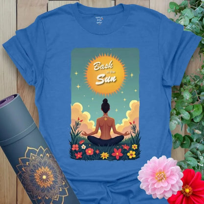 Soft cotton yoga t-shirt with meditating figure under a glowing sunrise and “Bask in the Sun” mantra, ideal for peaceful movement.