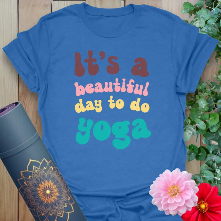 Soft cotton yoga tee with retro bubble letter quote “It’s a Beautiful Day to Do Yoga” in multicolor design.