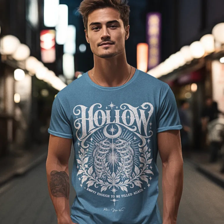 A man stands on a lantern-lit night market street, wearing the Hollow T-Shirt. Hollow T-Shirt is a Gildan 64000 and the color is Stone Blue.