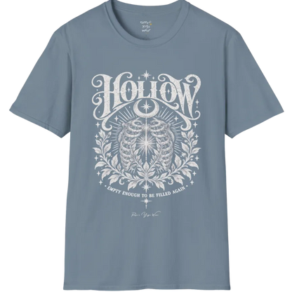 Symbolic ribcage engraving with a single glowing light at the center, crescent moon behind. Hollow T-Shirt flat lay is a Gildan 64000 and the color is Stone Blue.